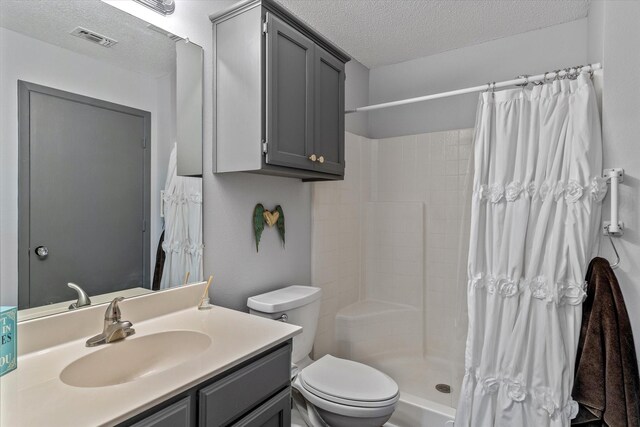 bathroom with a shower with shower curtain, vanity, a textured ceiling, and toilet