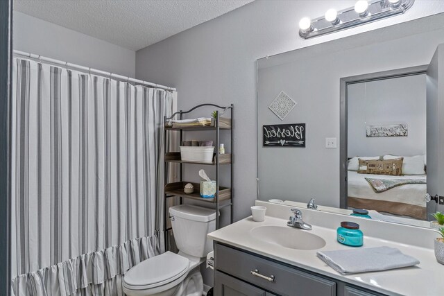 bathroom with walk in shower, vanity, a textured ceiling, and toilet