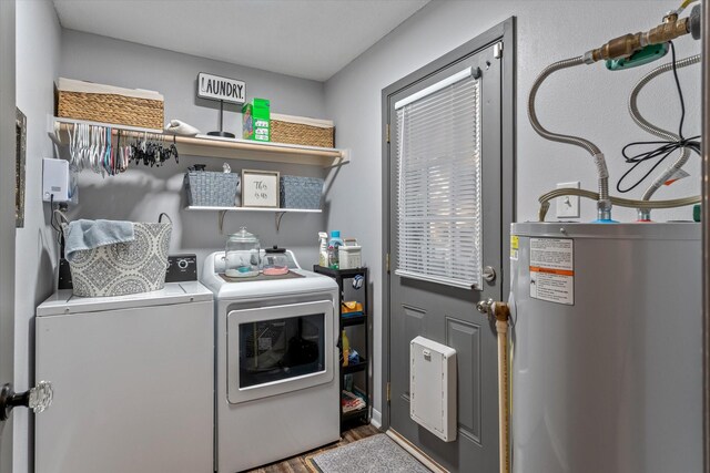 laundry room featuring hardwood / wood-style flooring, washing machine and dryer, and water heater