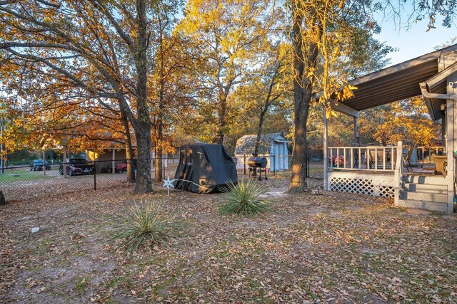 view of yard featuring a deck and a storage unit