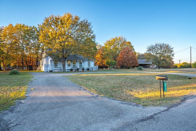 view of front of home with a porch and a front yard