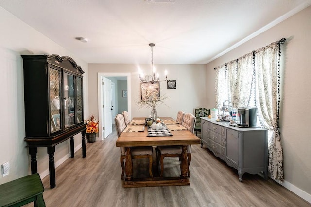 dining room featuring hardwood / wood-style floors and a notable chandelier