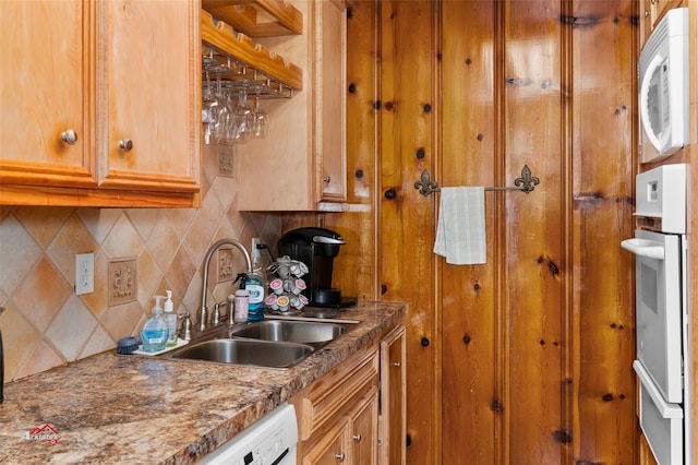 kitchen with tasteful backsplash, sink, white appliances, and dark stone countertops