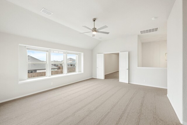 living room with lofted ceiling, light carpet, and a wealth of natural light