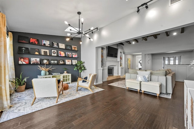 living room featuring dark wood-type flooring, vaulted ceiling, and a notable chandelier