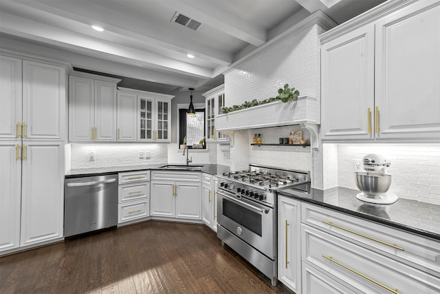 kitchen featuring appliances with stainless steel finishes, dark wood-type flooring, sink, beamed ceiling, and white cabinets