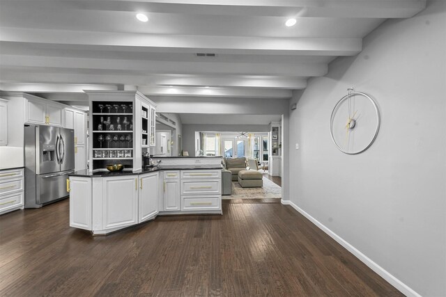 kitchen featuring kitchen peninsula, stainless steel refrigerator with ice dispenser, dark wood-type flooring, beam ceiling, and white cabinetry