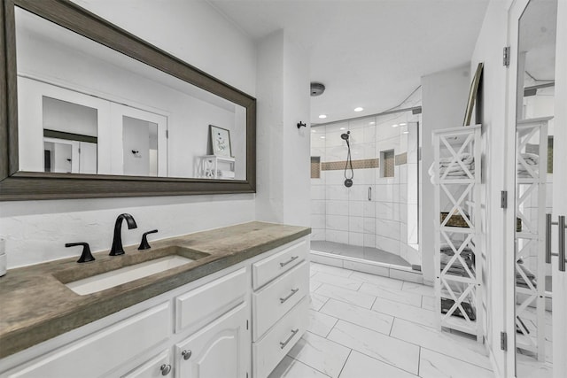 bathroom with tiled shower and vanity