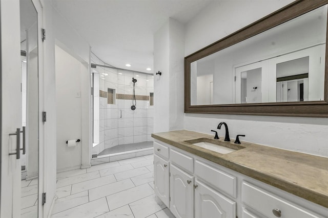 bathroom featuring a tile shower and vanity