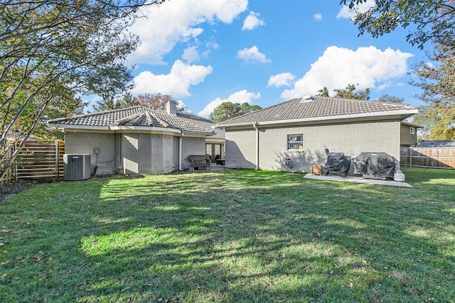 back of house with a lawn, a patio, and central AC