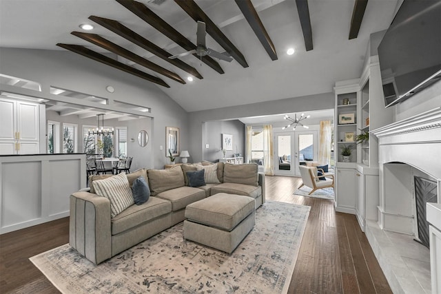 living room featuring a tile fireplace, french doors, vaulted ceiling with beams, wood-type flooring, and ceiling fan with notable chandelier