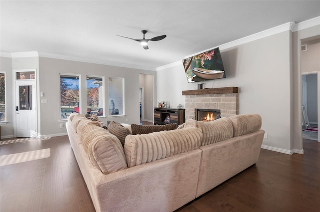 living room with crown molding, a stone fireplace, and dark wood-type flooring