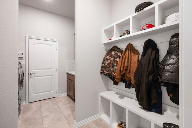 mudroom with separate washer and dryer and light tile patterned floors