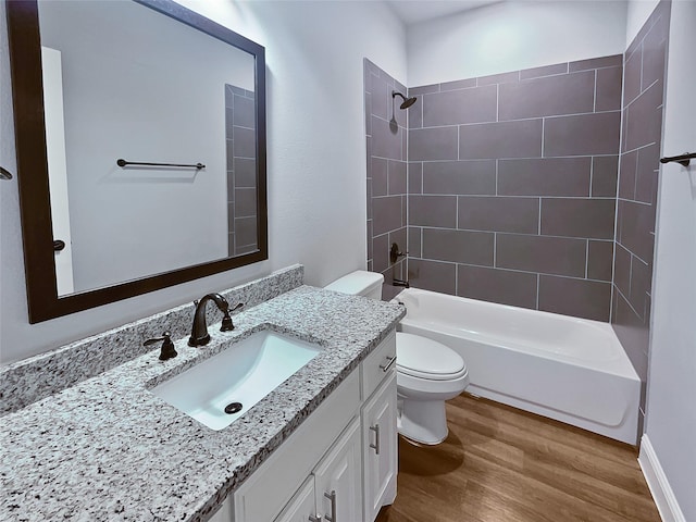 full bathroom with hardwood / wood-style floors, vanity, toilet, and tiled shower / bath