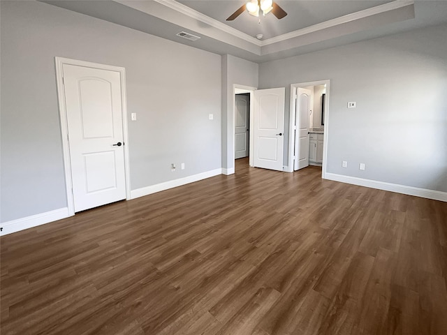 unfurnished bedroom featuring ornamental molding, a raised ceiling, ceiling fan, and dark wood-type flooring