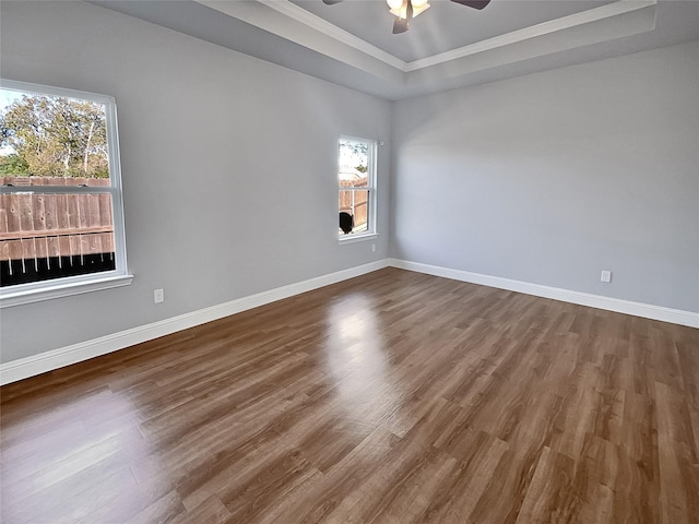 unfurnished room with ceiling fan, dark hardwood / wood-style floors, and a raised ceiling