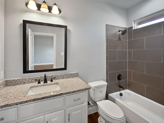 full bathroom with vanity, tiled shower / bath combo, and toilet