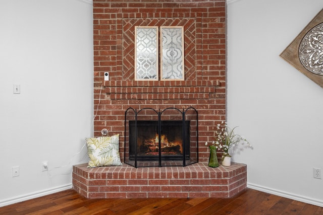 details with a brick fireplace, baseboards, and wood finished floors