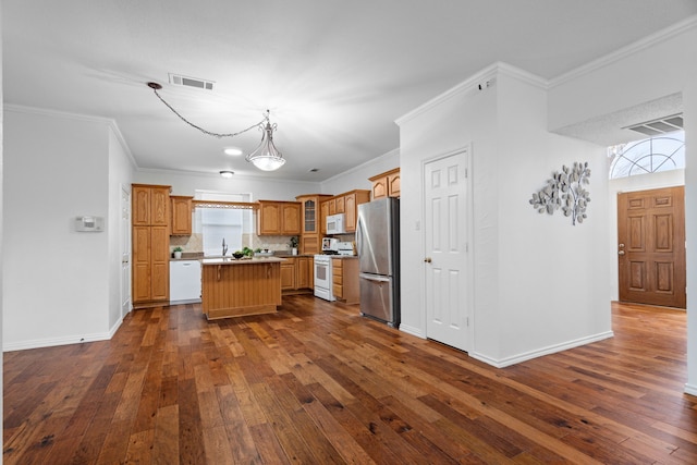 kitchen with white appliances, a kitchen island, visible vents, and dark wood-type flooring