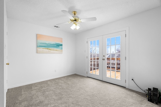 carpeted empty room with baseboards, visible vents, ceiling fan, a textured ceiling, and french doors