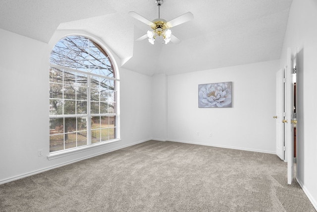 interior space featuring ceiling fan, carpet, baseboards, and vaulted ceiling