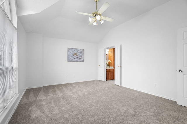 unfurnished bedroom with lofted ceiling, ceiling fan, carpet flooring, baseboards, and ensuite bath