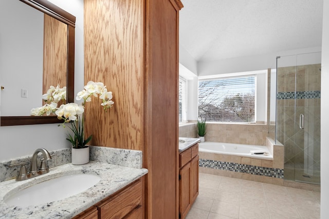 full bathroom featuring a garden tub, a stall shower, vanity, a textured ceiling, and tile patterned floors