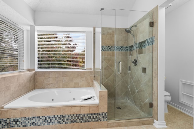 bathroom featuring a stall shower, a jetted tub, toilet, and tile patterned floors