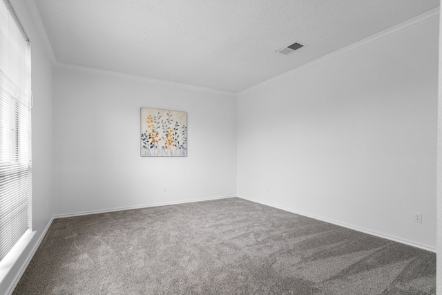 spare room with a textured ceiling, visible vents, baseboards, carpet, and crown molding