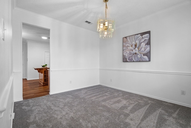 spare room featuring baseboards, visible vents, ornamental molding, an inviting chandelier, and carpet flooring