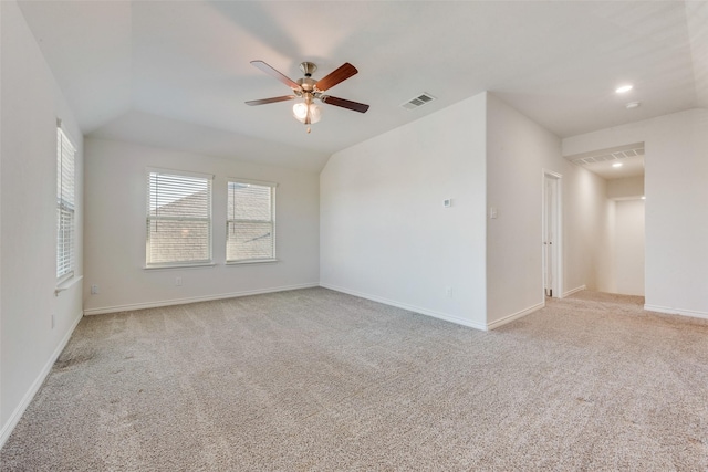 spare room with light carpet, ceiling fan, and vaulted ceiling