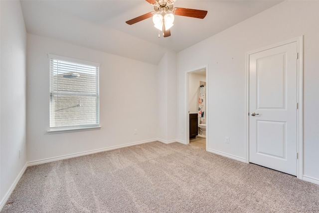 unfurnished bedroom with light carpet, connected bathroom, and ceiling fan