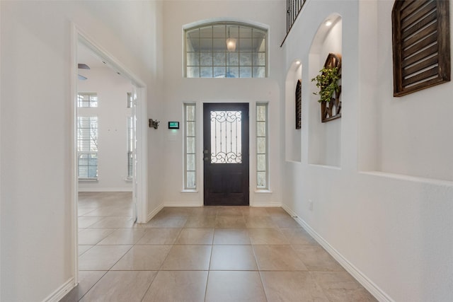 tiled foyer featuring a high ceiling and plenty of natural light