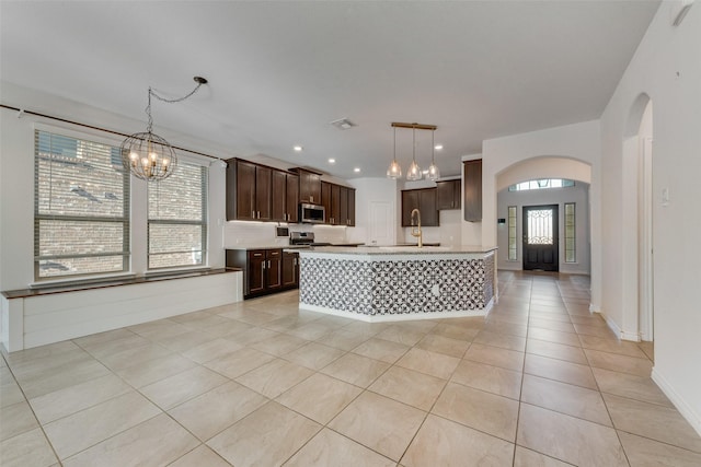 kitchen with pendant lighting, sink, appliances with stainless steel finishes, and a chandelier