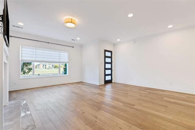 empty room with light hardwood / wood-style flooring