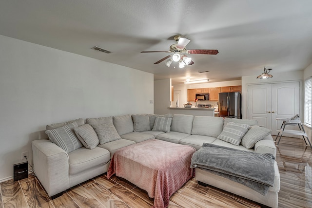 living room featuring ceiling fan and light hardwood / wood-style floors