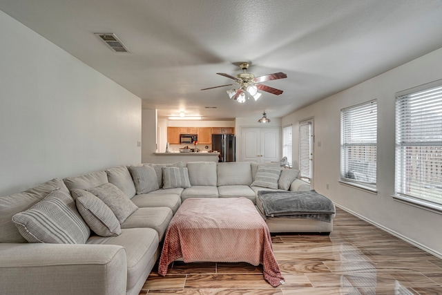 living room with ceiling fan and light hardwood / wood-style floors