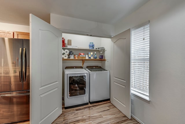 laundry area with washing machine and clothes dryer and light hardwood / wood-style flooring