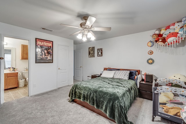 bedroom featuring ceiling fan, ensuite bathroom, and light carpet