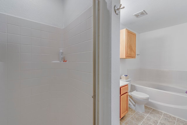 bathroom featuring vanity, a textured ceiling, a bath, tile patterned flooring, and toilet