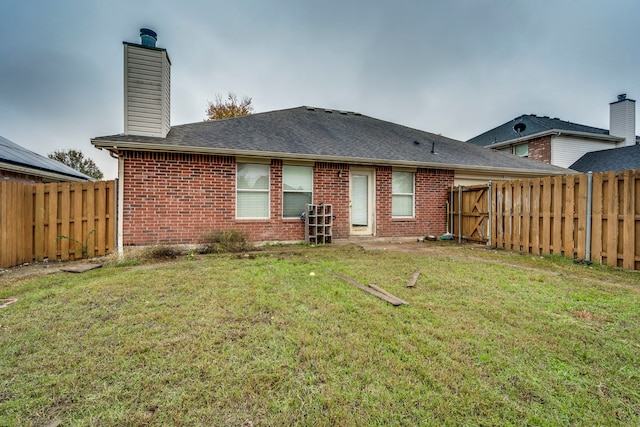 rear view of house featuring a yard