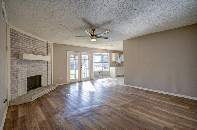 unfurnished living room with ceiling fan, french doors, wood-type flooring, a textured ceiling, and a fireplace