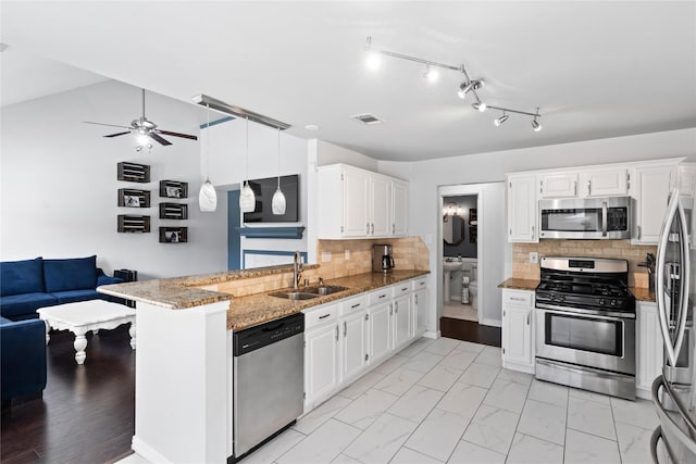 kitchen featuring light stone countertops, sink, white cabinets, and stainless steel appliances