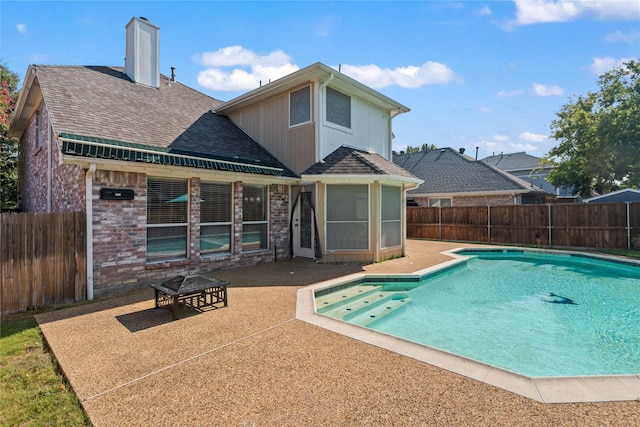 view of swimming pool with a patio and a fire pit