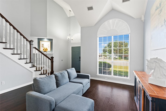 living room featuring dark wood-type flooring, high vaulted ceiling, and an inviting chandelier