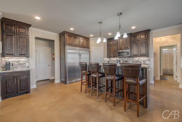 kitchen with dark brown cabinetry, decorative backsplash, pendant lighting, and appliances with stainless steel finishes