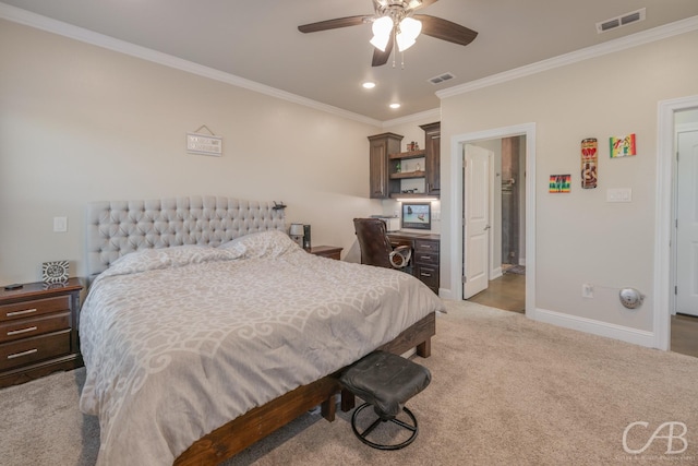 bedroom featuring ceiling fan, light colored carpet, ornamental molding, and ensuite bath