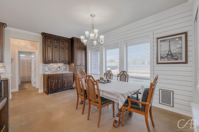 dining room featuring a chandelier, crown molding, and wood walls