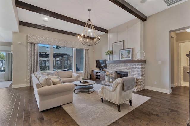 living room featuring beamed ceiling, dark hardwood / wood-style flooring, a chandelier, and a brick fireplace