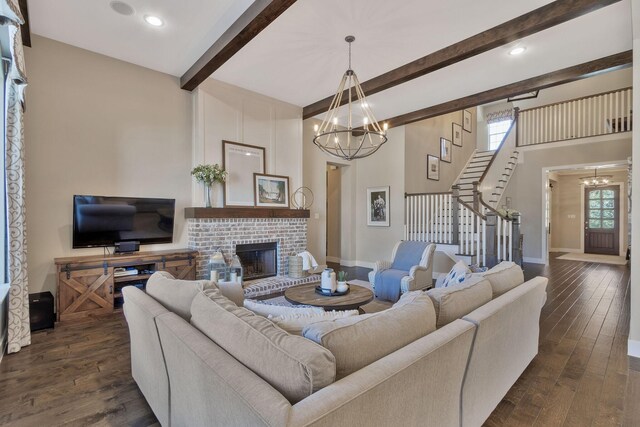 living room with a high ceiling, dark hardwood / wood-style floors, a fireplace, beamed ceiling, and a chandelier